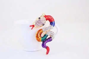 Macro view of a colorful snake pendant with vibrant segments and rhinestone-encrusted head