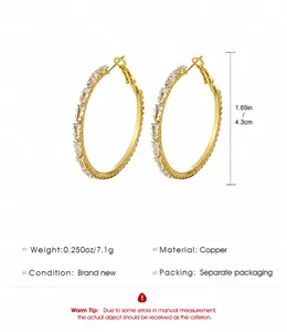 Detail view of 4.3cm golden hoop earrings with clear rectangular cubic zirconia inlay