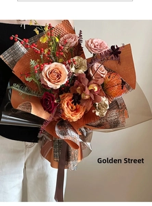 Luxurious holiday bouquet featuring champagne roses and red berries in premium textured wrap
