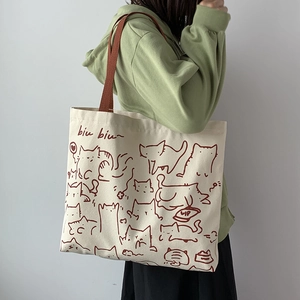 Artistic canvas tote bag with cat illustration and biu biu text shown on shoulder