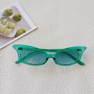 Detail view of stylish green oval sunglasses with translucent resin frame and cyan lenses