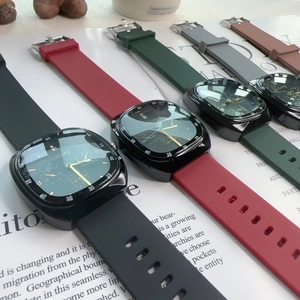 Detail view of square diamond-set quartz watches with colorful silicone straps on desk