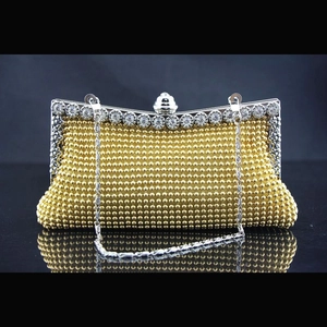 Detailaufnahme der goldenen Abendtasche mit Strassverschluss und silberner Kette