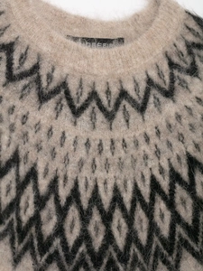 Dettaglio del girocollo e della morbida maglia jacquard in alpaca con motivi geometrici