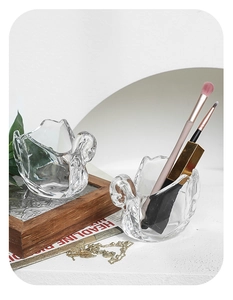 Macro detail of swan-shaped transparent glass storage jar for jewelry and makeup brushes