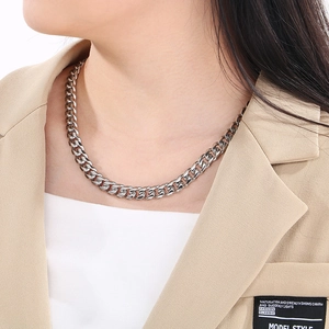 Close-up of 10mm silver Cuban chain necklace worn by a model in casual blazer