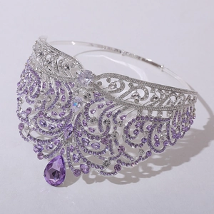 Macro detail of silver crown with purple rhinestones and large teardrop centerpiece