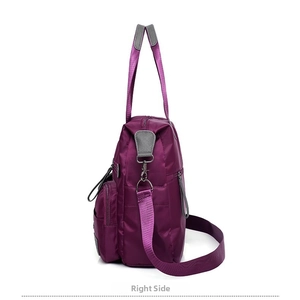 Side view of large purple nylon handbag with gray leather trim and silver metal hardware