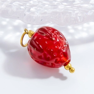 Detailed close-up of handmade realistic strawberry glass pendant with gold metal accents