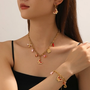 Golden jewelry set with enamel butterfly, ladybug and flower charms on model
