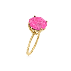 Close-up of a pink faceted gemstone ring with golden twisted band and four-prong setting