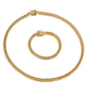 Detail of gold Cuban curb chain necklace and bracelet set with polished finish