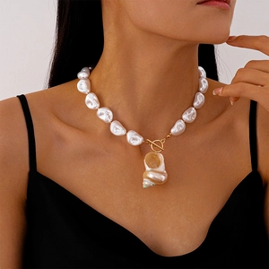 Detailed view of irregular faux pearls and natural conch shell necklace with T-bar clasp