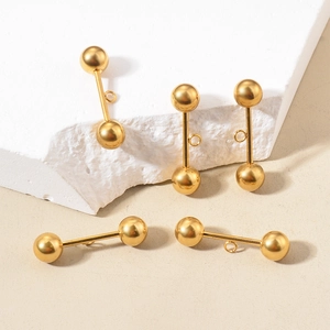 Detailed view of five gold stainless steel bead ear studs with hanging rings on stone