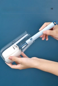 Long handle sponge cup brush cleaning the deep bottom of a glass against a blue background