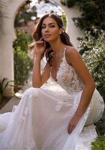 Detailed close-up of intricate 3D floral lace embroidery on a white V-neck bridal gown