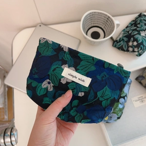 Detailed close-up of dark green floral jacquard mini fabric pouch with Simple Wish label