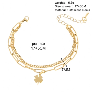 Gros plan du bracelet double couche en acier inoxydable doré avec pendentif trèfle et maillons