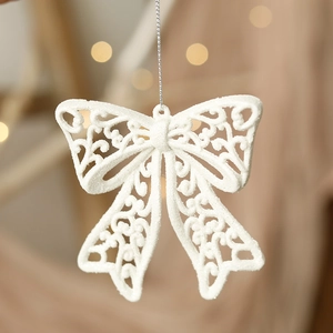 Detail of white glitter bow ornament with silver hanging string for Christmas trees