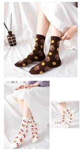 Close-up of cotton socks with cartoon bear and puppy patterns on white bedding