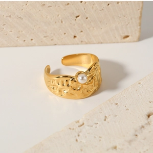 Macro detail of 18k gold irregular lava texture ring with a single white pearl accent
