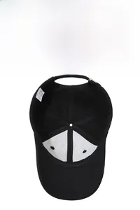 Detail of internal lining and 100% cotton wash label on a black baseball cap
