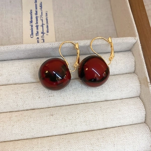 Close-up of marble resin ball earrings with gold french hooks in a white gift box