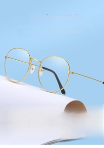 Detailed close-up of retro gold round metal glasses frame with clear silicone nose pads