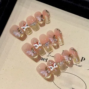 Macro detail of handmade cat-eye press-on nails with golden lion and butterfly charms