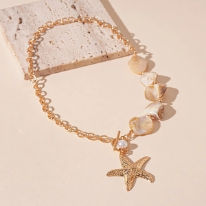 Detailed view of ocean style starfish pendant and irregular pearl beads on gold necklace