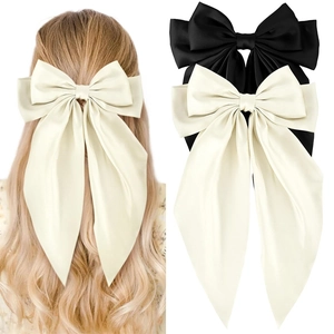 Detail of oversized double-layer satin bow hair clip with long ribbons for elegant styling