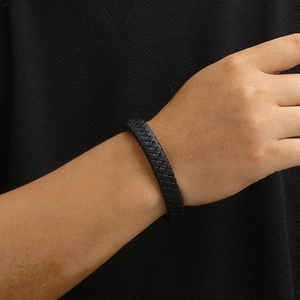 Detail of black braided leather texture and craftsmanship on men's bracelet worn on wrist