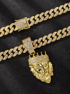 Detailed macro view of golden lion head pendant with sparkling rhinestones and cuban chain