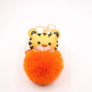 Close-up of orange faux rabbit fur pom pom with PU leather cartoon tiger keychain detail