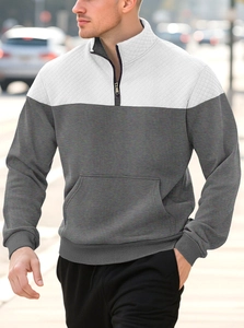 Outdoor shot of men's quarter-zip sweatshirt featuring quilted texture and stand collar