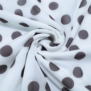 Detailed macro shot of white fabric with black polka dots showing mesh texture and drape