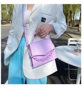 Detail of trendy purple crossbody bag with chunky chain decoration and leather texture