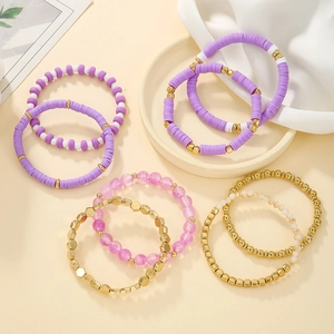 Macro shot of colorful handmade polymer clay beads and gold metal spacers on elastic bracelets