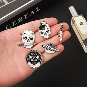 Gothic punk metal brooch set held in hand featuring skeleton, black cat and bloody dagger