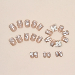 Short square champagne press-on nails with 3D white bow and silver glitter accents