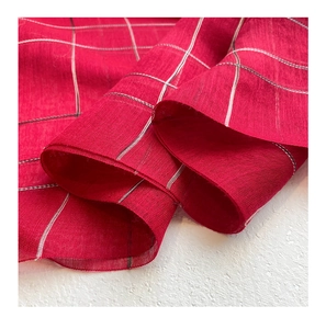 Macro view of lightweight red grid pattern silk wool fabric with elegant sheer texture