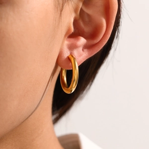 Chunky gold stainless steel hoop earring shown on a model with a high-polished finish
