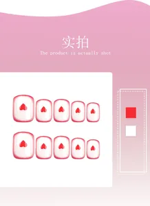 Detail of square press-on nails with red heart motifs and French red border tips