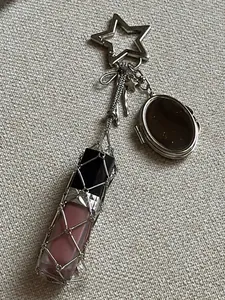 Detail of silver mesh lipstick holder keychain featuring a pink gloss and star-shaped clip
