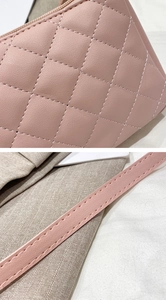 Detail of pink quilted PU leather handbag with fine stitching and slim shoulder strap