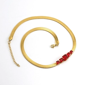 Detailed view of a gold-plated snake chain necklace featuring a red zircon gemstone