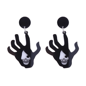 Detailed view of gothic acrylic earrings featuring hand palm shape with skull cutouts