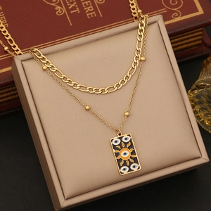 Detail of double-layer gold necklace with evil eye sun pendant on jewelry box