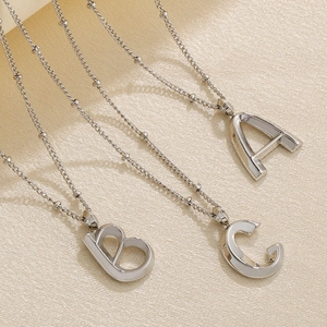Macro detail of silver-tone stainless steel alphabet A B C pendants on bead chains