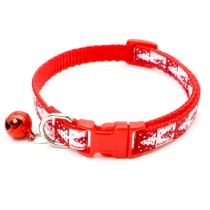 Detail of red Christmas pet collar with white tree print, red bell and safety buckle